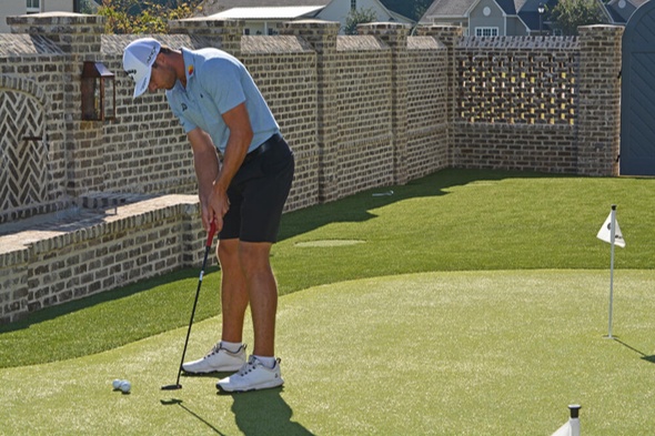 Metro New York Golfer putting on synthetic grass